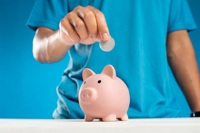 person-putting-money-into-a-piggy-bank